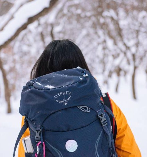 A woman carrying an Osprey backpack, one of the best hydration packs for women